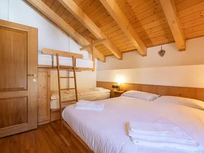a bedroom with a bed with two towels on it at Apartment Cesa degli Abeti by Interhome in Campitello di Fassa