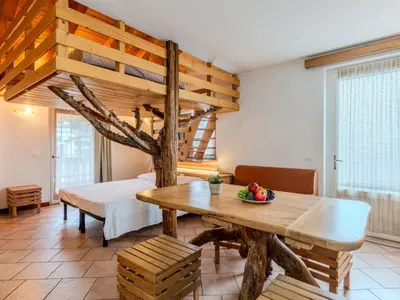 a bedroom with a bed in a room with wooden ceilings at Apartment Vento Alpino-2 by Interhome in Predaia