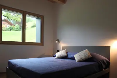 a bedroom with a blue bed with a window at VILLA IRIS 6 persone in Transacqua