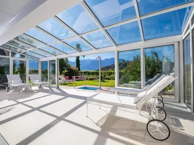 a glass house with a view of the mountains at Hotel Mühle Mayer in Termeno