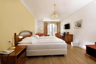 a bedroom with two beds and a desk with a phone at Hotel Mühle Mayer in Termeno
