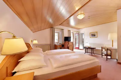 a large bedroom with two beds and a lamp at Hotel Mühle Mayer in Termeno