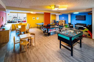 a room with two tables and a pool table at Vitalpina Hotel Waldhof in Rablà