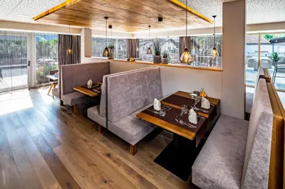 a dining room with two chairs and a table at Vitalpina Hotel Waldhof in Rablà
