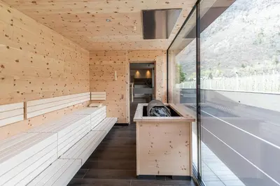 an empty sauna with wooden walls and benches at Vitalpina Hotel Waldhof in Rablà