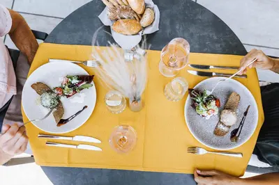 a yellow table with plates of food on it at Vitalpina Hotel Waldhof in Rablà