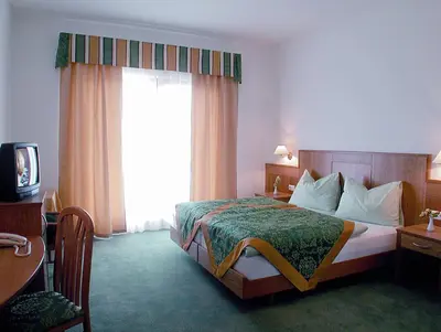 a hotel room with a bed and a window at Gardenhotel Premstaller in Bolzano