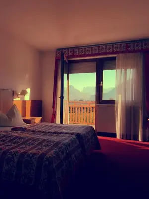 a bedroom with a bed and a window with a view at Gardenhotel Premstaller in Bolzano