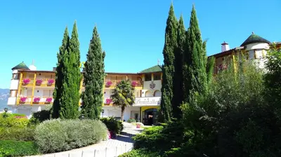 a building with trees in front of it at Gardenhotel Premstaller in Bolzano