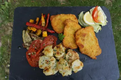 a blue plate of food with shrimp and vegetables at Guesthouse Dolomiten in Egna