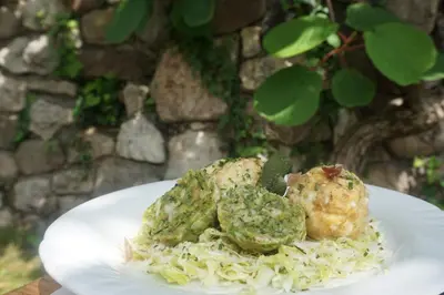 a plate of food with potatoes and pesto on pasta at Guesthouse Dolomiten in Egna