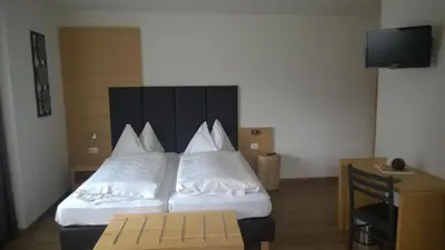 a bedroom with two beds with white pillows at Guesthouse Dolomiten in Egna