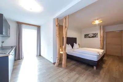 a bedroom with a bunk bed and a kitchen at Guesthouse Dolomiten in Egna