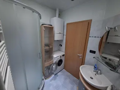 a small bathroom with a washing machine and a sink at Apartment Anna in Merano