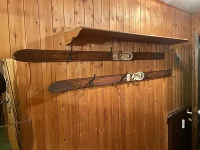 two skis are hanging on a wooden wall at CIASA LAURINA - Apartment near the slopes with Dolomite views in Carezza al Lago