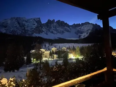 a view of a resort in the mountains at night at CIASA LAURINA - Apartment near the slopes with Dolomite views in Carezza al Lago