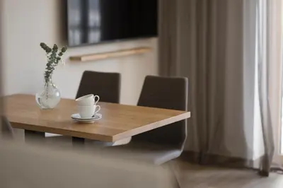 a wooden table with a cup and a vase on it at Residence Sonja in Rablà