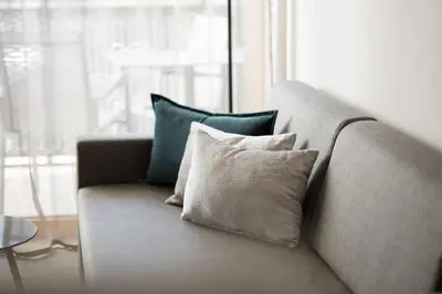 a couch with four pillows on it in a living room at Residence Sonja in Rablà