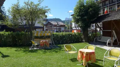 a group of chairs and a table in a yard at Hotel Bellaria - Cortina d'Ampezzo in Cortina dʼAmpezzo