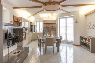 a kitchen with a table and chairs and a ceiling at All'Uno, Taio Ospitar in Taio