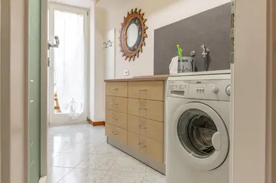 a laundry room with a washing machine and a mirror at All'Uno, Taio Ospitar in Taio
