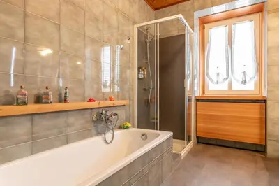 a bathroom with a tub and a shower and a window at All'Uno, Taio Ospitar in Taio