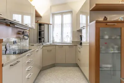 a large kitchen with white cabinets and a window at All'Uno, Taio Ospitar in Taio