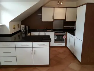 a kitchen with white cabinets and a black counter top at Apartment Manuel in Ortisei