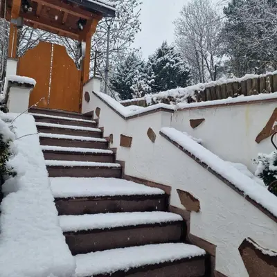 a staircase covered in snow in front of a house at Appartamento Genzianella Monolocale in Cavalese