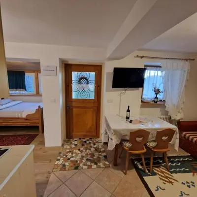 a small living room with a table and a door at Appartamento Genzianella Monolocale in Cavalese