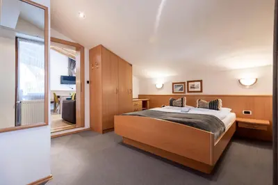 a bedroom with a large bed and a large window at Waldelerhof- Appartements in Meransen in Maranza