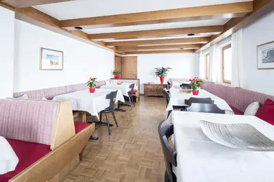 a dining room with white tables and chairs at Waldelerhof- Appartements in Meransen in Maranza