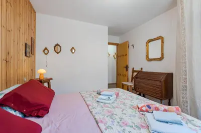 a bedroom with a bed and a mirror and a dresser at Appartamento Vittoria in Cavalese