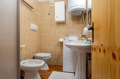 a small bathroom with a toilet and a sink at Appartamento Vittoria in Cavalese