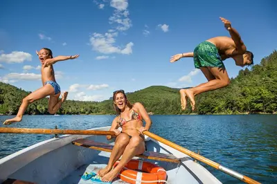 a group of people jumping off of a boat at Lafoi - Apartments in Eppan in Cornaiano