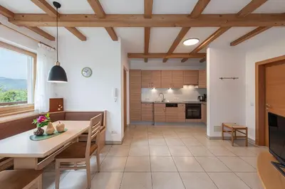 a kitchen and living room with a table and chairs at Lafoi - Apartments in Eppan in Cornaiano