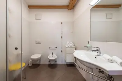a white bathroom with a sink and a toilet at Lafoi - Apartments in Eppan in Cornaiano