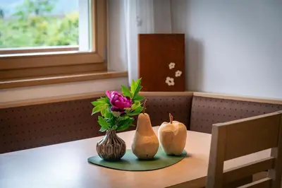 a table with a vase of flowers and two pumpkins at Lafoi - Apartments in Eppan in Cornaiano