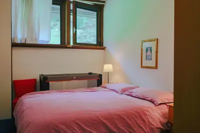 a bedroom with a red bed with a window at Residence SOLARIA in Campestrin