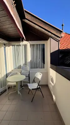 a patio with a table and chairs on a balcony at mardolomiti suite in Appiano sulla Strada del Vino