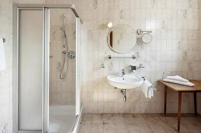 a bathroom with a tub and a toilet and a sink at Kalterer See Hof in Caldaro