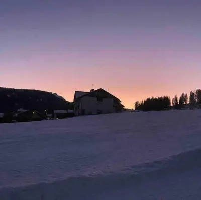 a snowy field with a house in the background at Luxury panoramic apartment Plan de Corones in Tesido