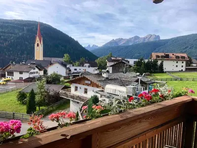 a view of a town with flowers on a balcony at Luxury panoramic apartment Plan de Corones in Tesido