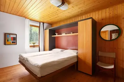 a bedroom with a bed and a mirror in a room at VILLA MARGHERITA - 5 minutes from Dolomiti Super Ski in Ziano di Fiemme