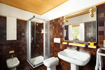 a bathroom with a sink and a toilet and a mirror at VILLA MARGHERITA - 5 minutes from Dolomiti Super Ski in Ziano di Fiemme