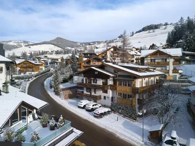 a snow covered town with buildings and cars parked at Alpen Suite Apartment in San Vigilio Di Marebbe