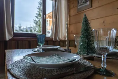 a table with a plate and a christmas tree on it at Alpen Suite Apartment in San Vigilio Di Marebbe
