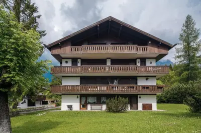 a large building with a balcony on top of it at Ca Miramonti - Garden and Tofana view in Cortina dʼAmpezzo