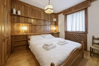 a bedroom with a large bed with towels on it at Ca Miramonti - Garden and Tofana view in Cortina dʼAmpezzo