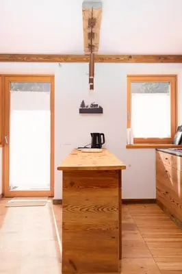 a kitchen with a wooden counter and two windows at Arga' New Alpine Design Apartment Central & Scenic Views in San Vito di Cadore